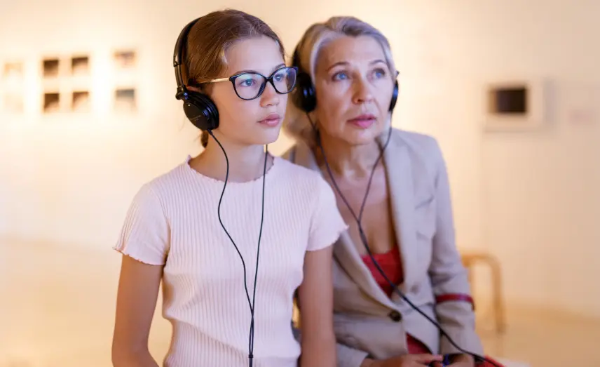 Visiteuses en galerie d'art avec un audioguide